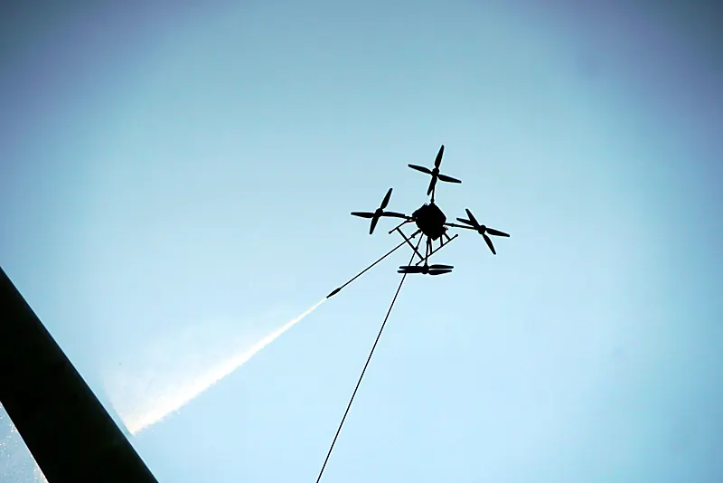 Reinigingsdrone met waterstraal tegen een blauwe lucht